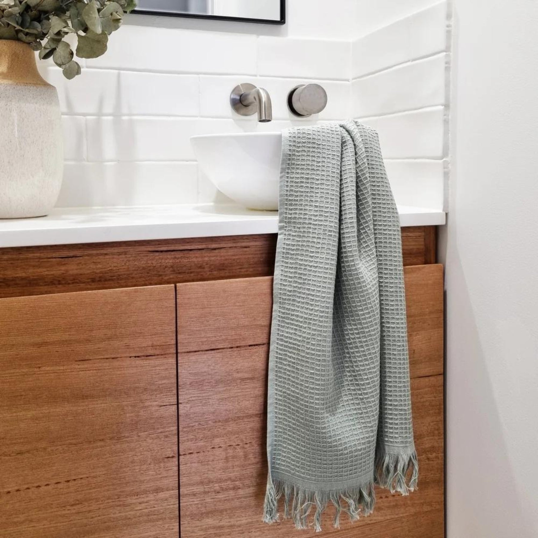 Camila Set of 2 Cotton Waffle Hand Towels in a muted Pistachio hue, styled in bathroom setting