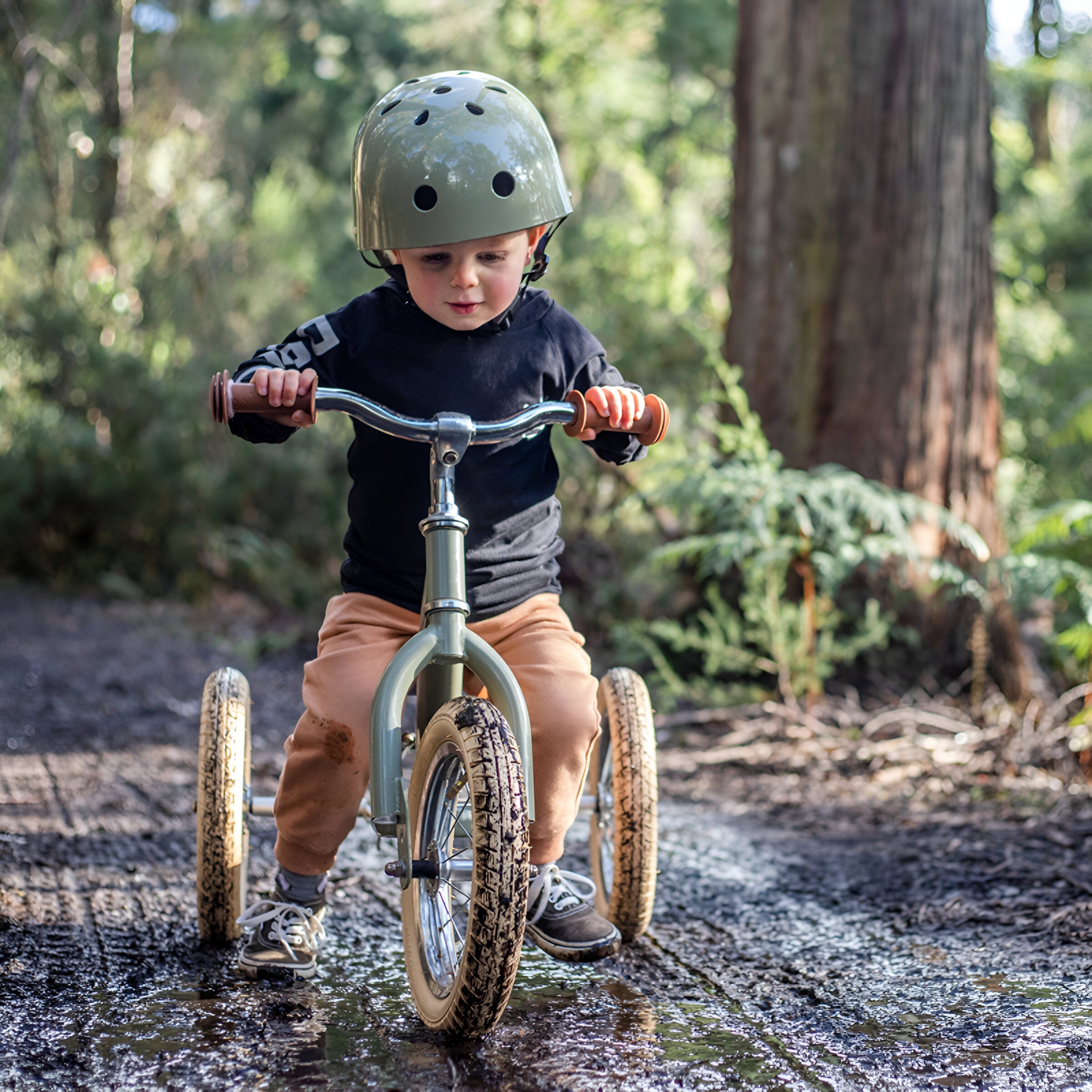 Child enjoying a ride in the forest on Trybike Vintage Green