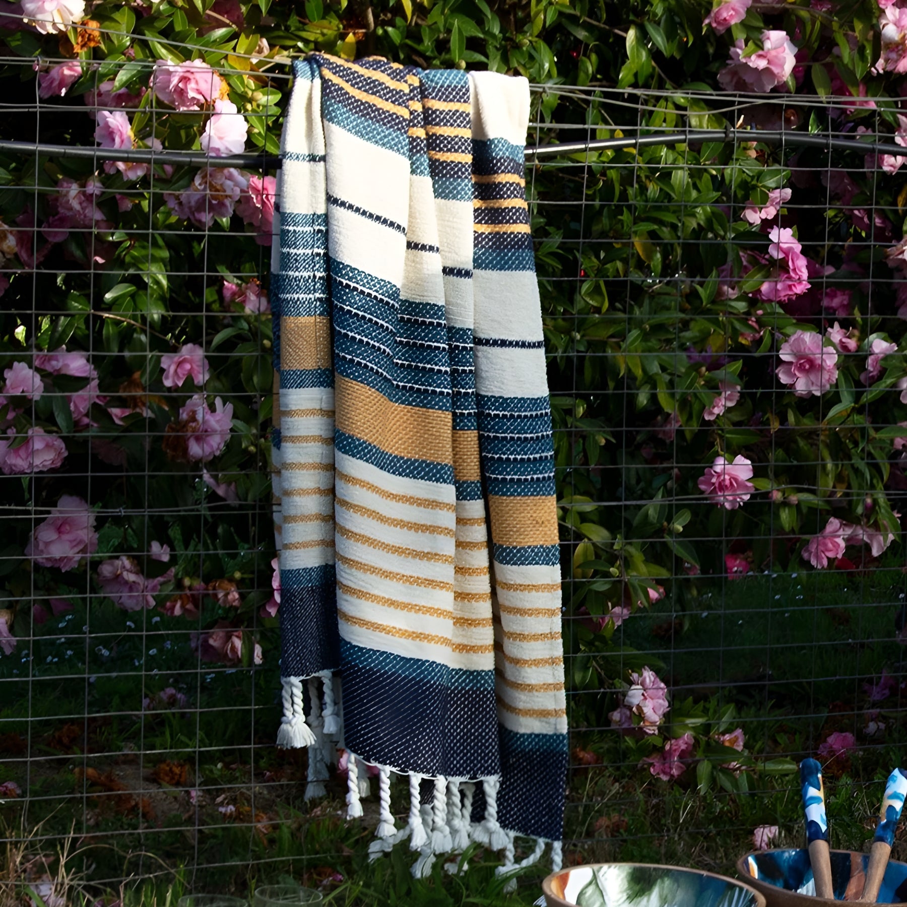 Lifestyle image of Zephyr throw rug in Blue Hues against a natural outdoor backdrop, blending comfort with style